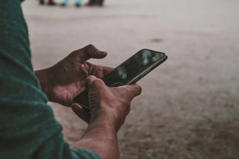 a person holding a cell phone in their hands