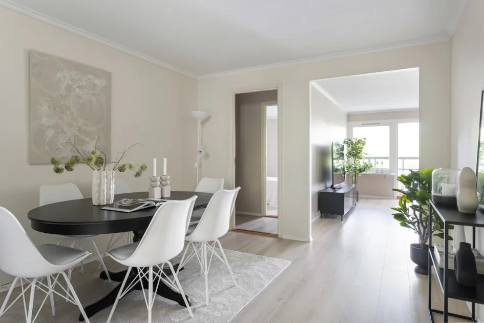 A dining room with a table and white chairs