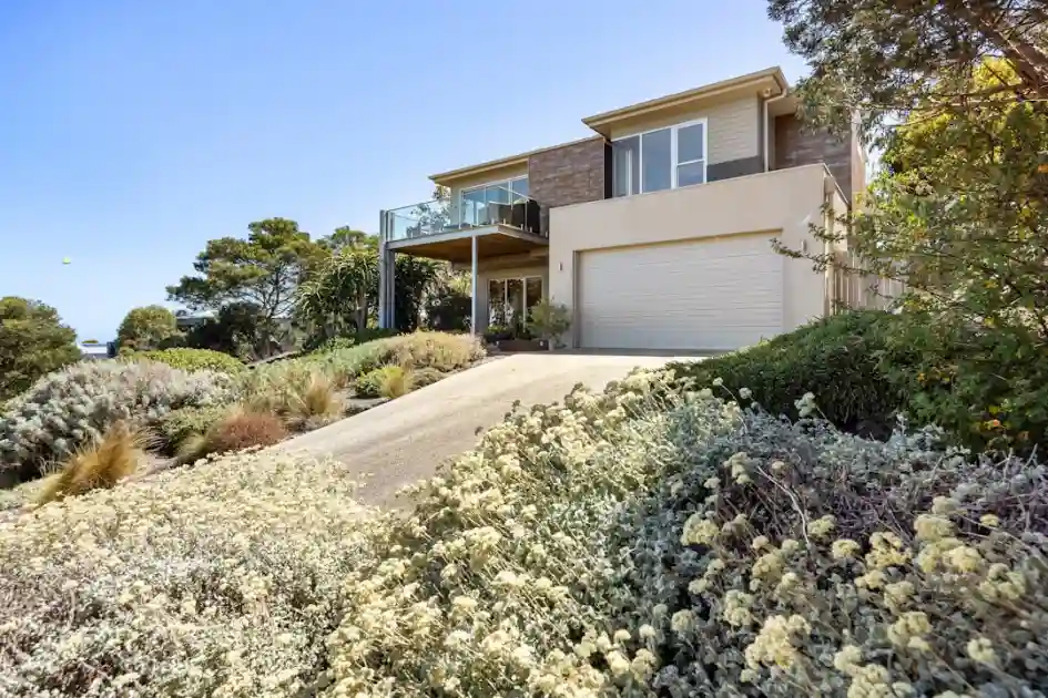 A house with a lot of trees and bushes in front of it