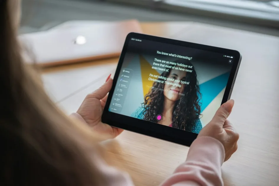 Woman holding a digital tablet showing a smiling woman