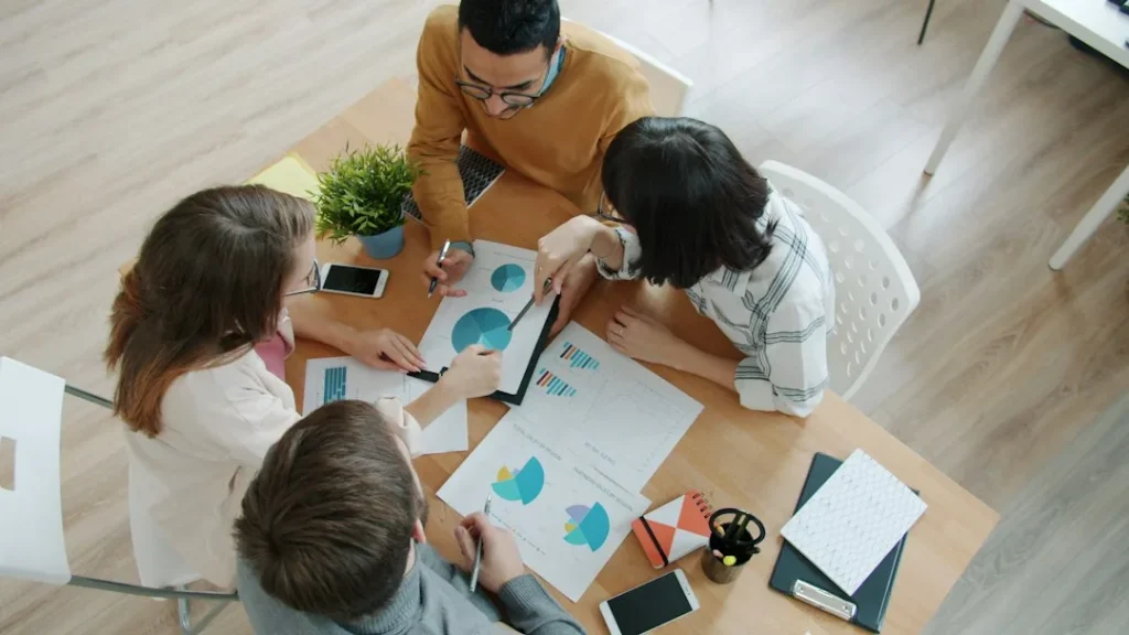 Team collaborating around a table with charts